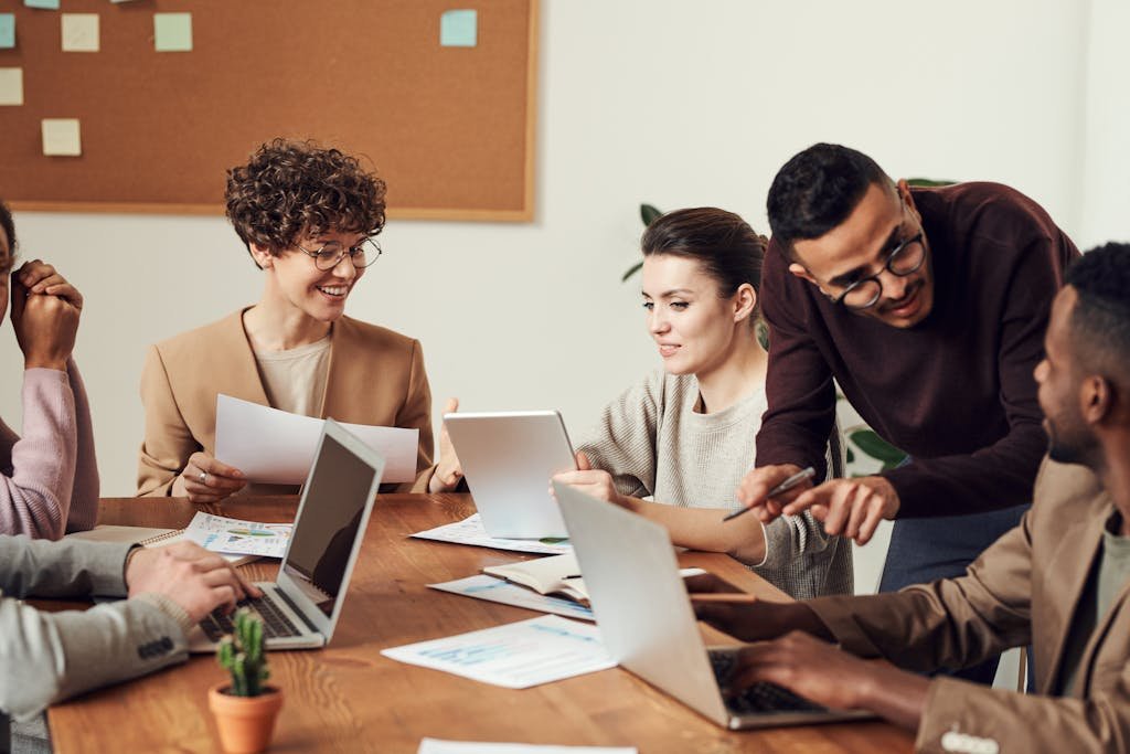 A diverse group of professionals engaged in a collaborative office meeting, sharing ideas and discussing projects.