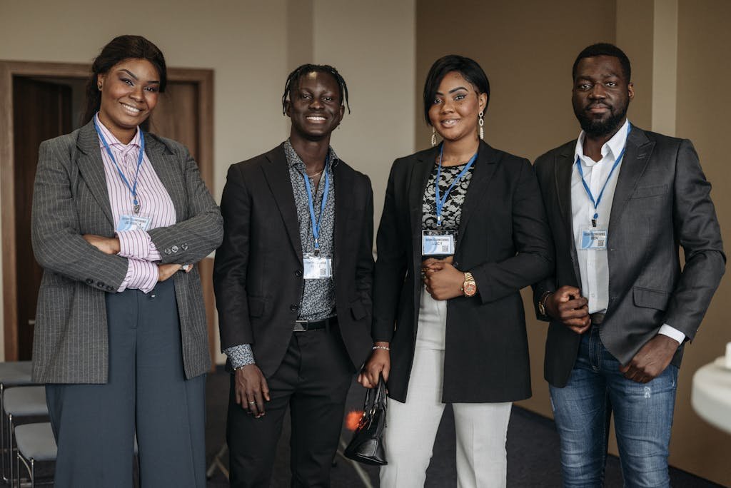 A diverse group of professionals smiling in corporate attire indoors.