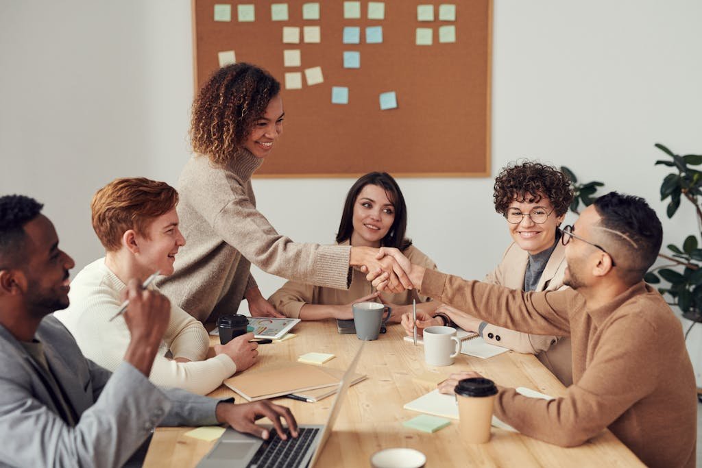 Diverse team collaborating in a meeting, showcasing teamwork and cooperation in a modern workplace.